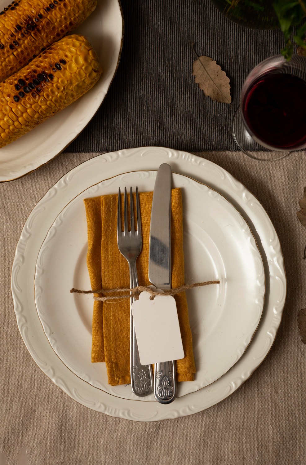 A formal place setting with folded napkin, cutlery and wine